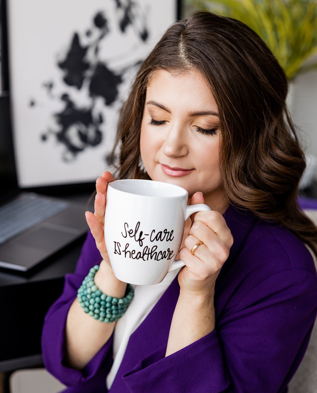 Adriane sipping Self-Care is Healthcare mug